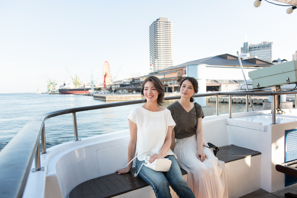 写真：神戸港の海で遊覧船に乗る二人の女性