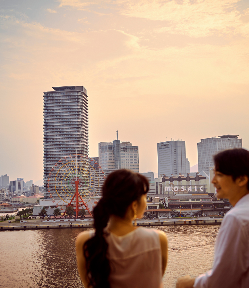写真：神戸メリケンパークオリエンタルホテルのベランダからカップルが神戸港の景色を見る様子
