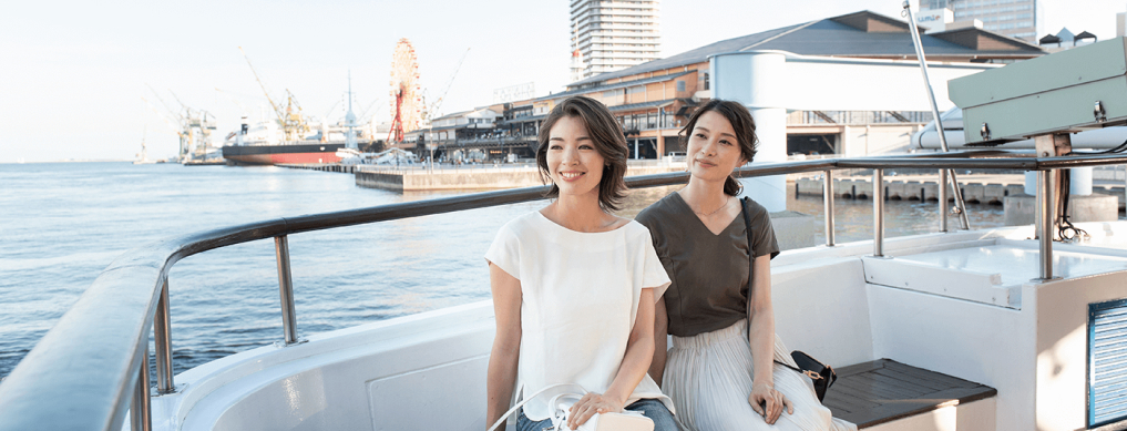 写真：神戸港の海で遊覧船に乗る二人の女性